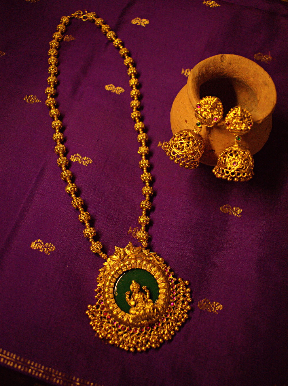Gold Lakshmi Medallion Necklace with Green Stone and Matching Jhumka Earrings